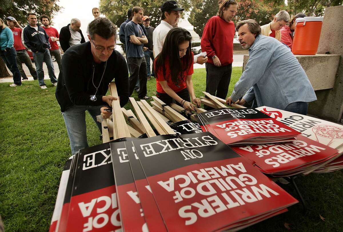 Writer's Guild staffers prepare signs to distribute for a picket around the NBC Studios in Burbank, Calif., during the start of the 2007 strike. That strike halted productions on numerous shows, led to a shortened television season and even affected major film releases.