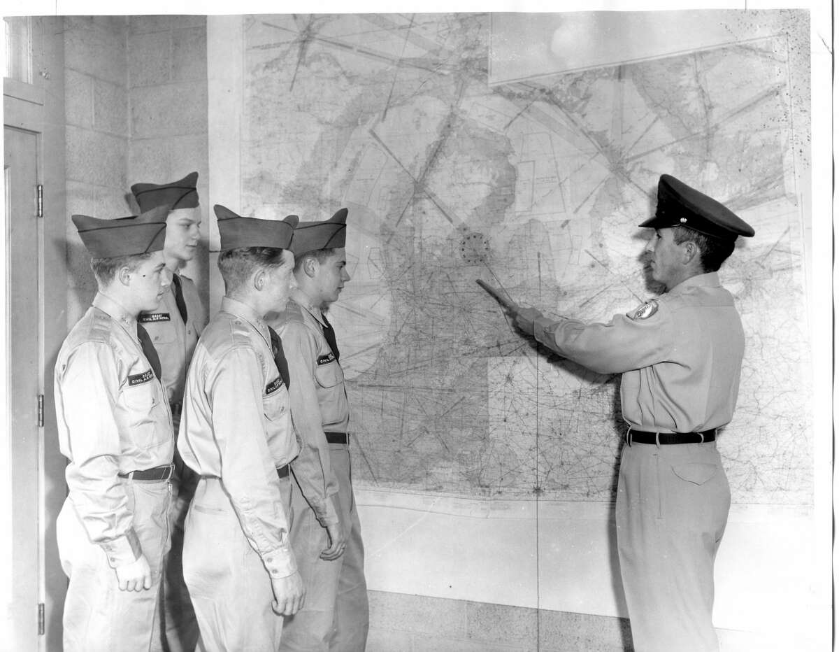 Civil Air Patrol L. J. Melstad, far right, squadron educational officer for the local group, instructs four cadets how to solve problems in map reading, The cadets are, from left, Bruce Henne, Donald Johnson, David Merritt and Mike Grinnell. December 1957