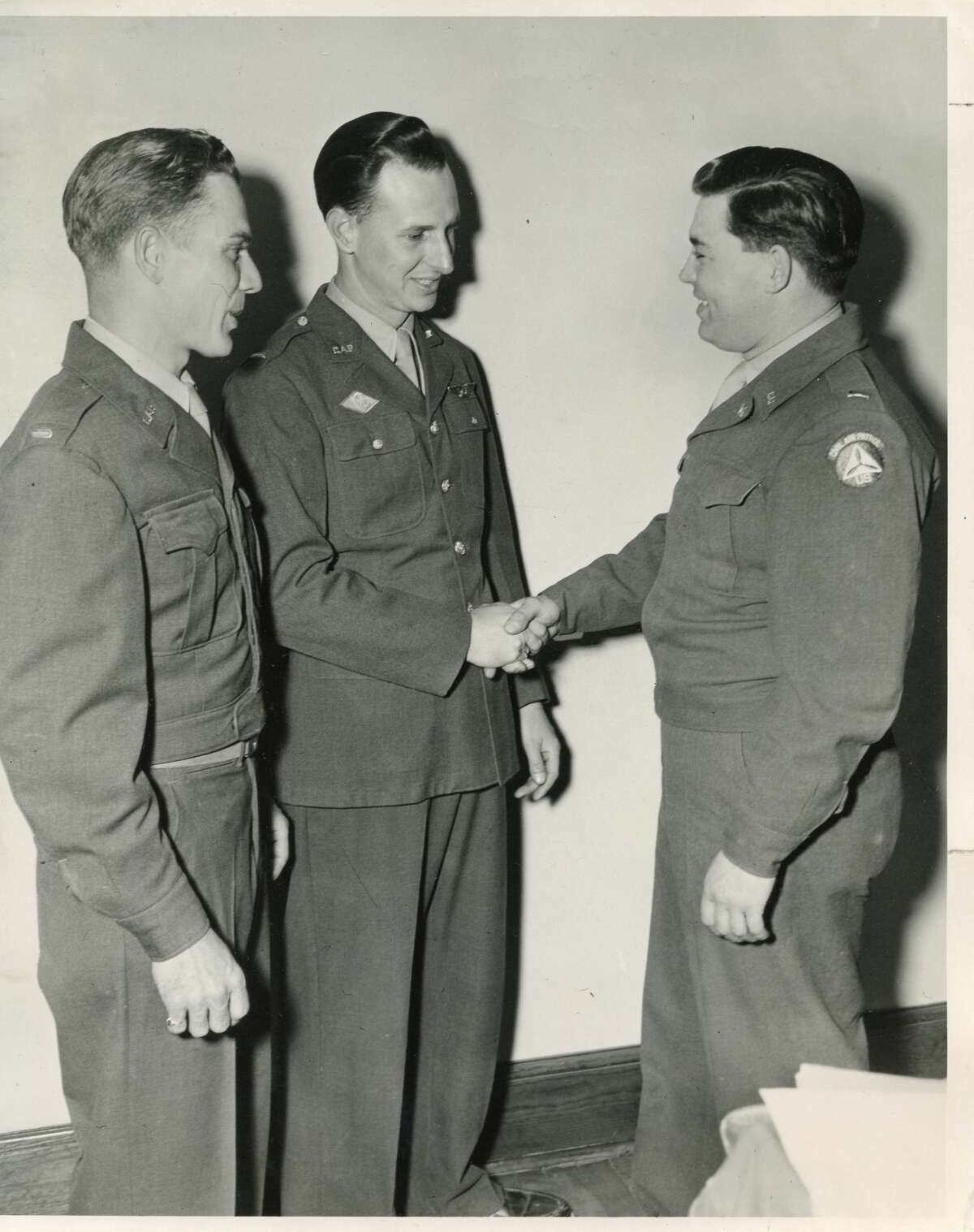Promotions come in Civil Air Patrol. Getting their Warrant Officer promotions are, from left, Harold Loose and Arnold Green. Lt. Fred Varner offers his congratulations. July 1950