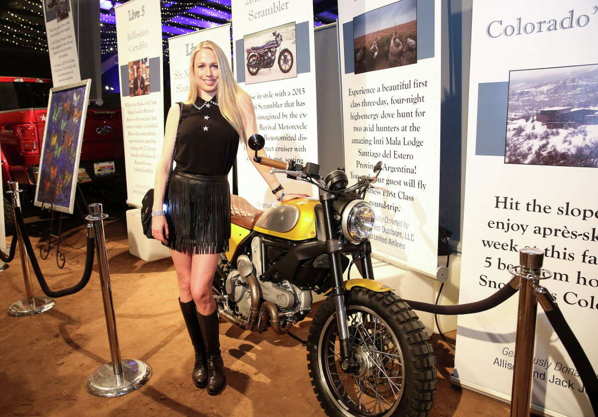 Lori Sarofim poses for a photo with a 2015 Ducati Scrambler that she donated at Cattle Baron's Ball at George Ranch Historical Park Saturday, April 29, 2017, in Richmond.