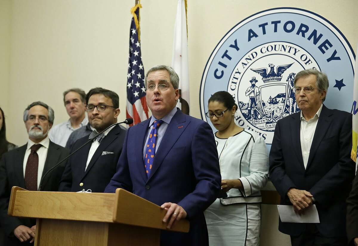 City Attorney Dennis Herrera, at podium, talks about a settlement agreement on short term rentals during a news conference Monday, May 1, 2017, at City Hall in San Francisco. San Francisco and Airbnb have reached a deal to end a lawsuit over a law that fines the company for booking rentals not registered with the city. Under the settlement announced Monday, residents looking to list a rental can apply for a city registration number through Airbnb's website. Standing behind Herrera from left are San Francisco Supervisor Aaron Peskin, labor leader Mike Casey, former supervisor David Campos, Board of Supervisors President London Breed and Doug Engmann of ShareBetter SF. (AP Photo/Eric Risberg)