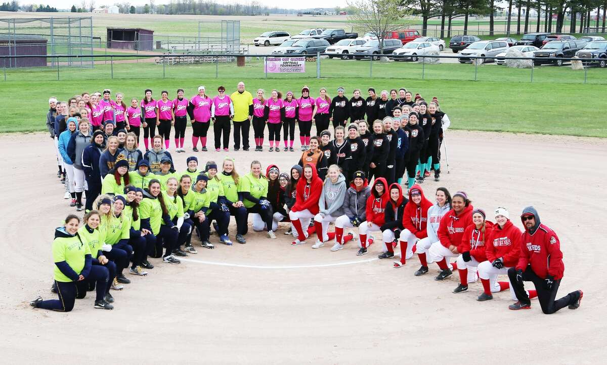   Members of the Ubly, Deckerville, Port Huron Northern and Port Huron High softball form a ribbon, Saturday, during the Striking Out Cancer Softball Tournament, in Deckerville. 