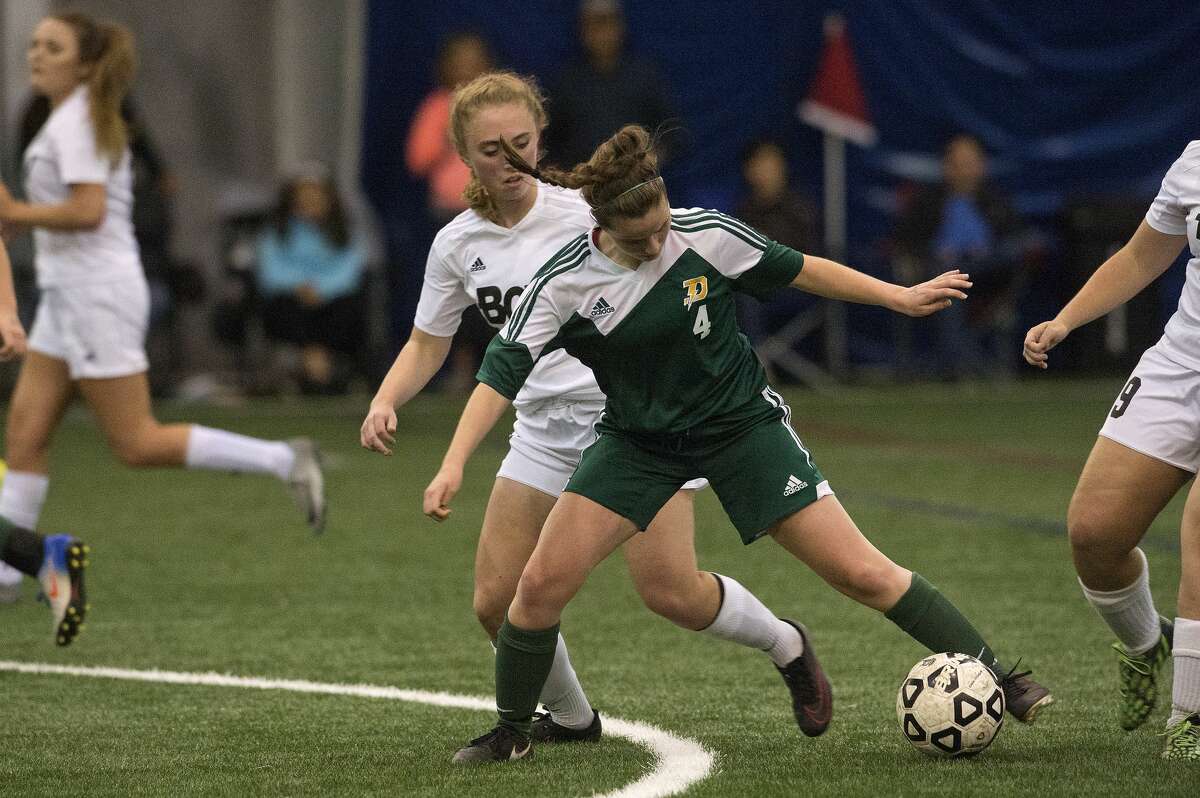 Dow's Logan Rosenbrock works to keep the ball away from Bay City Western's Mia Bacigalupo in the first half of the soccer game Monday evening.