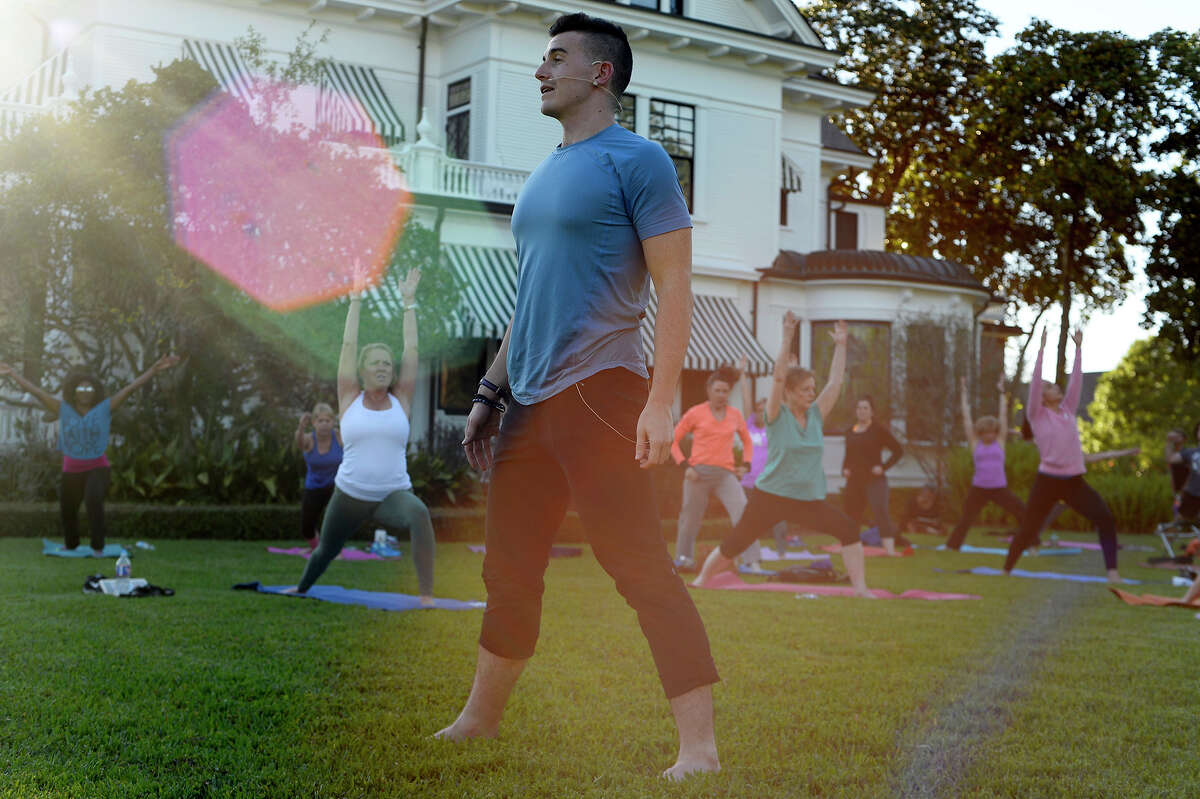 Nick Wolny, a Houston-based yoga instructor, leads a class on the lawn of the McFaddin-Ward House on Monday evening. The McFaddin-Ward House Museum will host their spring picnic on the lawn on Thursday evening. Photo taken Monday 5/1/17 Ryan Pelham/The Enterprise