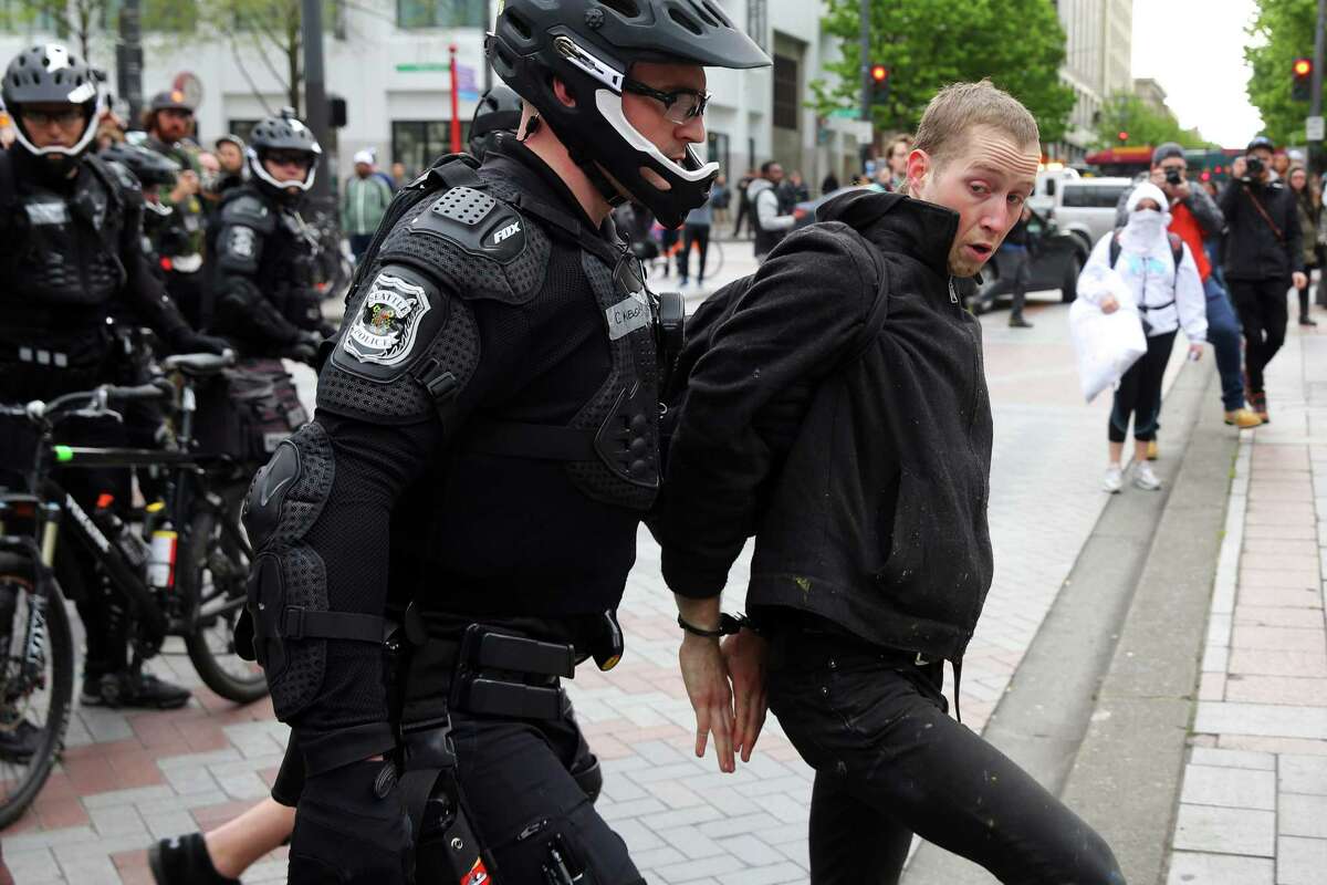 A man is arrested after he allegedly threw a rock as anti-fascist demonstrators clash with Trump supporters and police at Westlake Park during an evening demonstration, May Day 2017 in Seattle.
