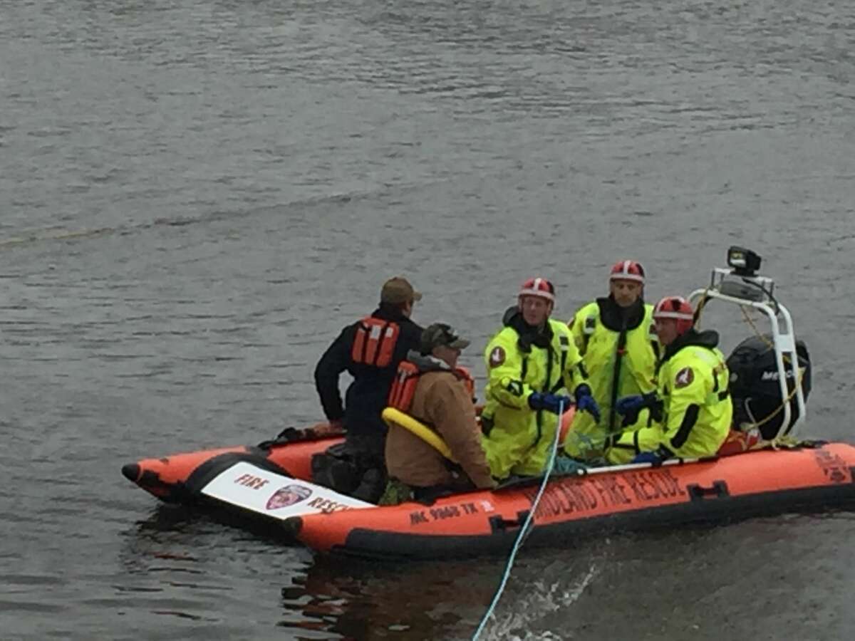   Rescuers respond after two boaters become trapped at the Dow dam on the Tittabawassee River on Saturday morning in Midland.