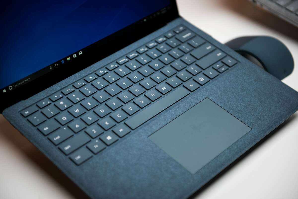 The new Microsoft Corp. Surface laptop computer sits on display during the #MicrosoftEDU event in New York, U.S., on Tuesday, May 2, 2017. Microsoft Corp. introduced a slim, $999 laptop, its latest push into hardware and a bid to steal Apple Inc.'s college-kid customers. The device comes in four colors, gold, platinum, blue, and burgundy and ditches a metal area around the keyboard for soft microfiber. Photographer: Mark Kauzlarich/Bloomberg