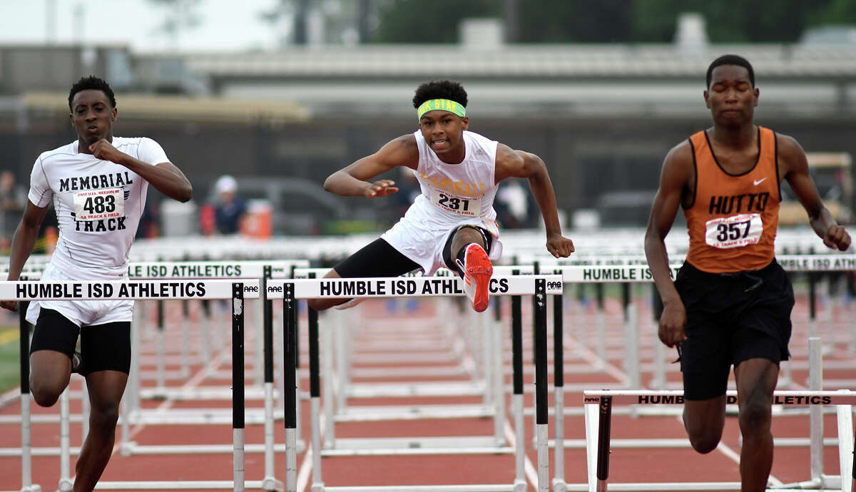 Fort Bend Marshall sophomore Dominick Houston-Shepard, center, pushes to the finish line against Port Arthur Memorial senior Bryan Moore, left, and Hutto junior De'Vion Wilson, right, during the Men's 110 Meter Hurdles at the UIL Region III-5A Track Meet at Turner Stadium on April 29, 2017. (Photo by Jerry Baker/Freelance)
