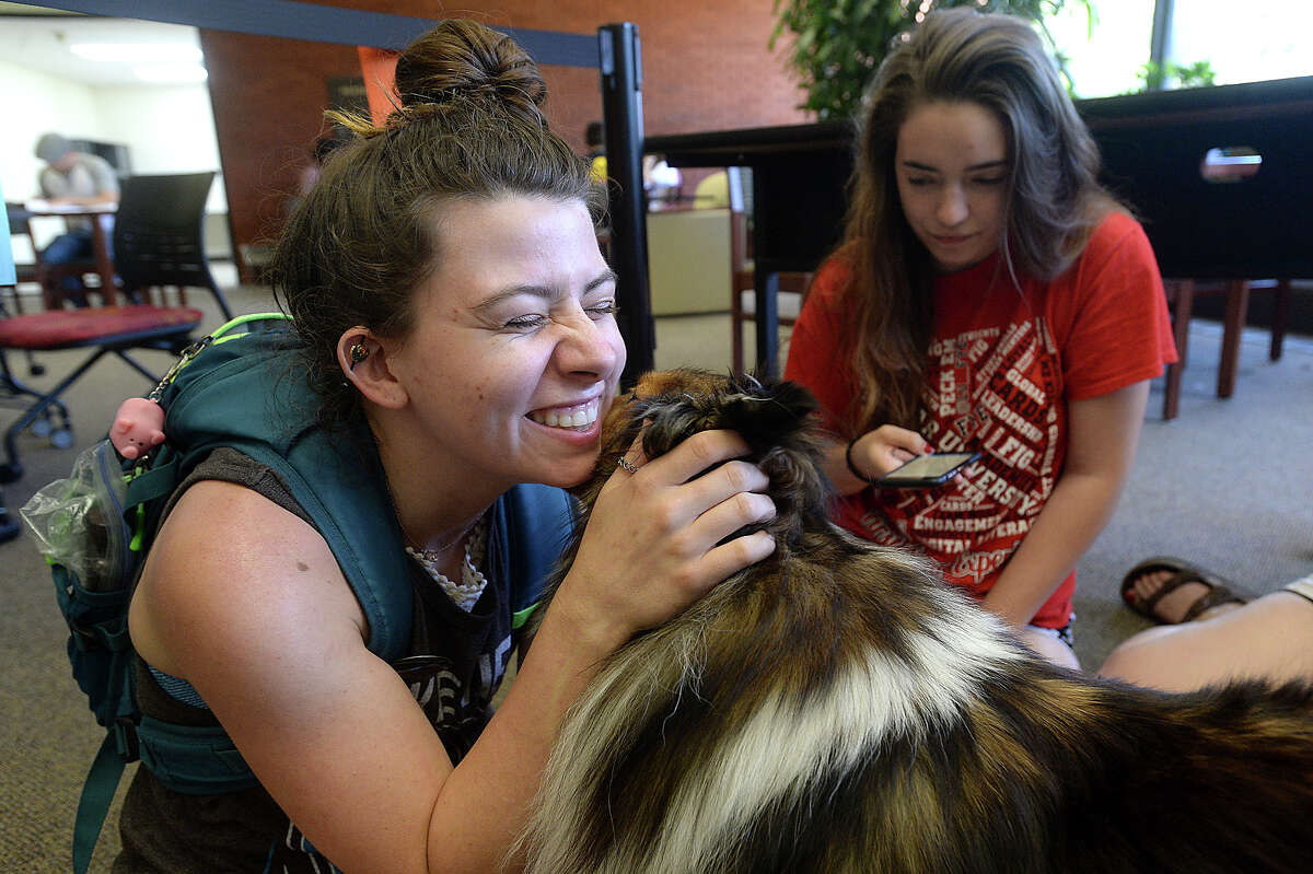 Lamar's Katie Cook Douglas cuddles with Suzi as she and friend Bethany Mobley stop to visit with the therapy dogs from the group Paws 4 Love at the library Tuesday. The dogs are spending time at the library helping students de-stress as they prepare for final exams this week. The group regularly comes to the library during finals weeks throughout the school year, offering a much needed break and bringing smiles to the faces of those whom they encounter. Photo taken Tuesday, May 2, 2017 Kim Brent/The Enterprise
