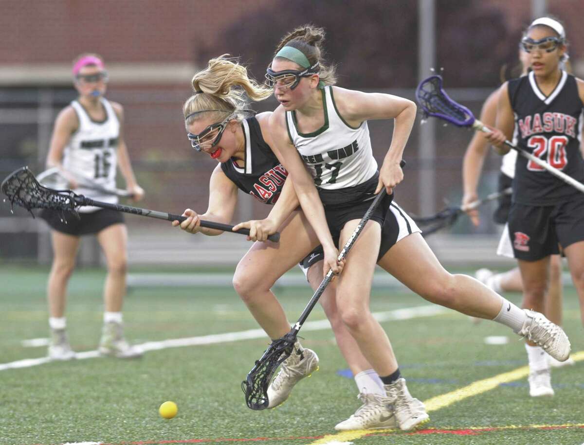 New Milford's Kelly Flynn (17) and Masuk's Alexia Kocis (28) collide as the go for the ball in the girls lacrosse game between Masuk and New Milford high schools, on Tuesday night, May 2, 2017, at New Milford High School, in New Milford, Conn.