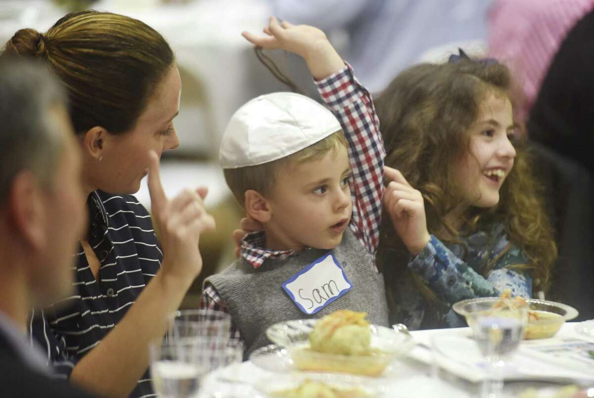 Greenwich's Melissa Levin dances along to a Seder song with her children Sam, 2, and Abby, 7, at the Interfaith Musical Seder at Temple Sholom in Greenwich, Conn. Monday, April 10, 2017. The gathering celebrated the first night of Passover with a traditional Seder meal and music from Sheldon Low.