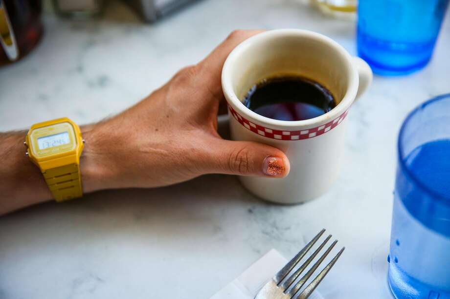 (l-r) Parker Higgins, of San Francisco, grabs a cup of coffee while showing off his Casio watch and bronze sparkly nail polish while eating at brunch spot St. Francis Fountain in San Francisco, California, on Sunday, April 23, 2017. Photo: Gabrielle Lurie / The Chronicle