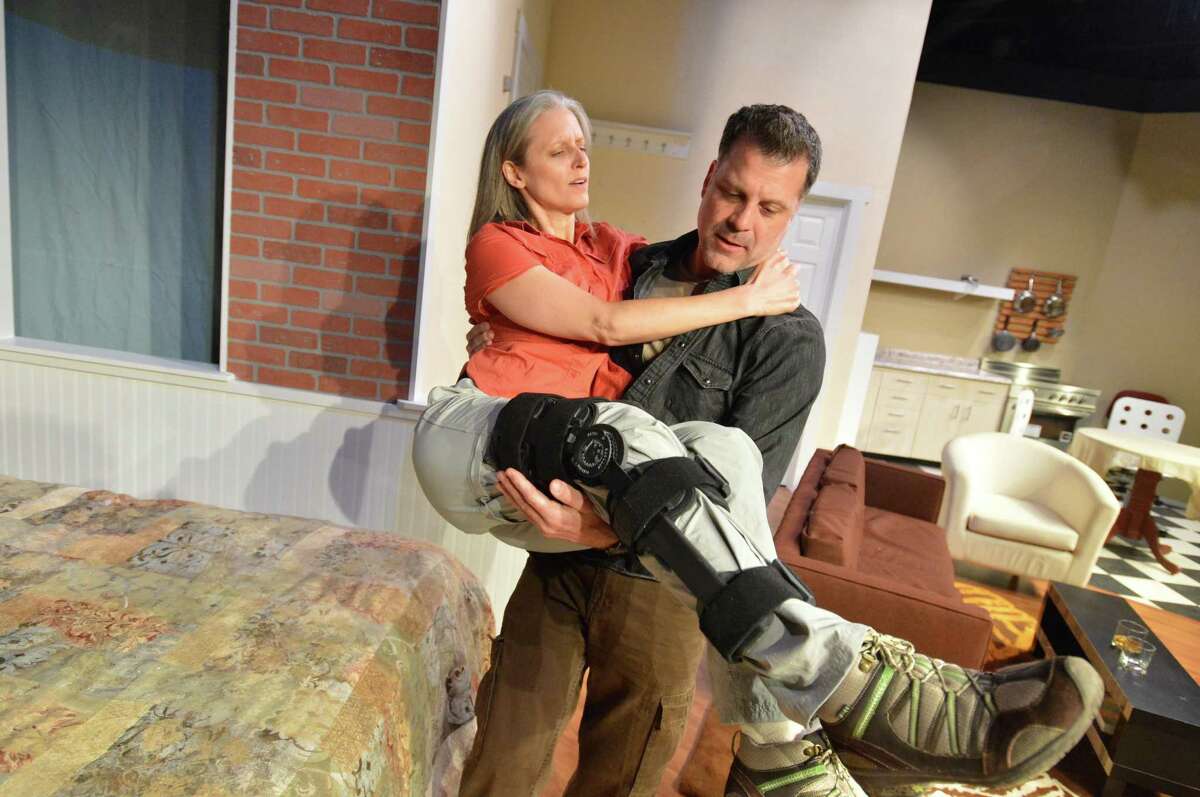 Collene Torres as Sarah Goodwin an injured photojournalist is lifted to the bedroom by Frank Speranzo as her boyfriend James Dodd in The Town Players of New Cannan production of Time Stands Still, on Thursday April 27, 2017 in New Canaan Conn.
