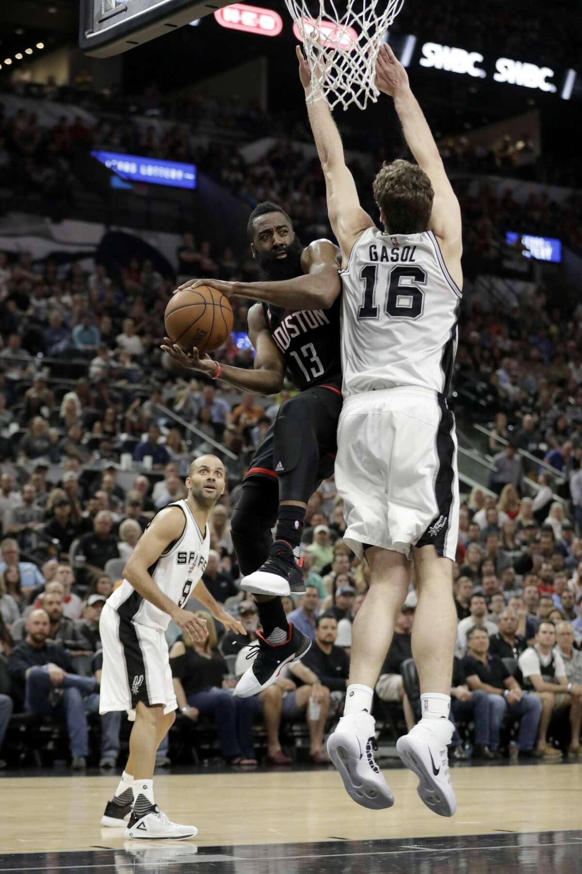 Houston Rockets guard James Harden is forced to pass the ball as San Antonio Spurs' Tony Parker, left, of France and Pau Gasol, (16), of Spain defend during the first half of Game 2 in a second-round NBA basketball playoff series, Wednesday, May 3, 2017, in San Antonio. (AP Photo/Eric Gay)