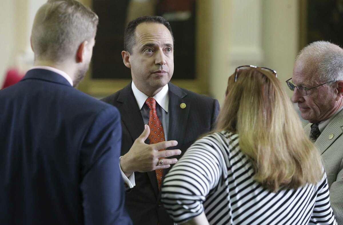 Senator Jose Menendez chats with his staff as he introduces bullying legislation on the floor of the Texas Senate on Wednesday, May 3, 2017.