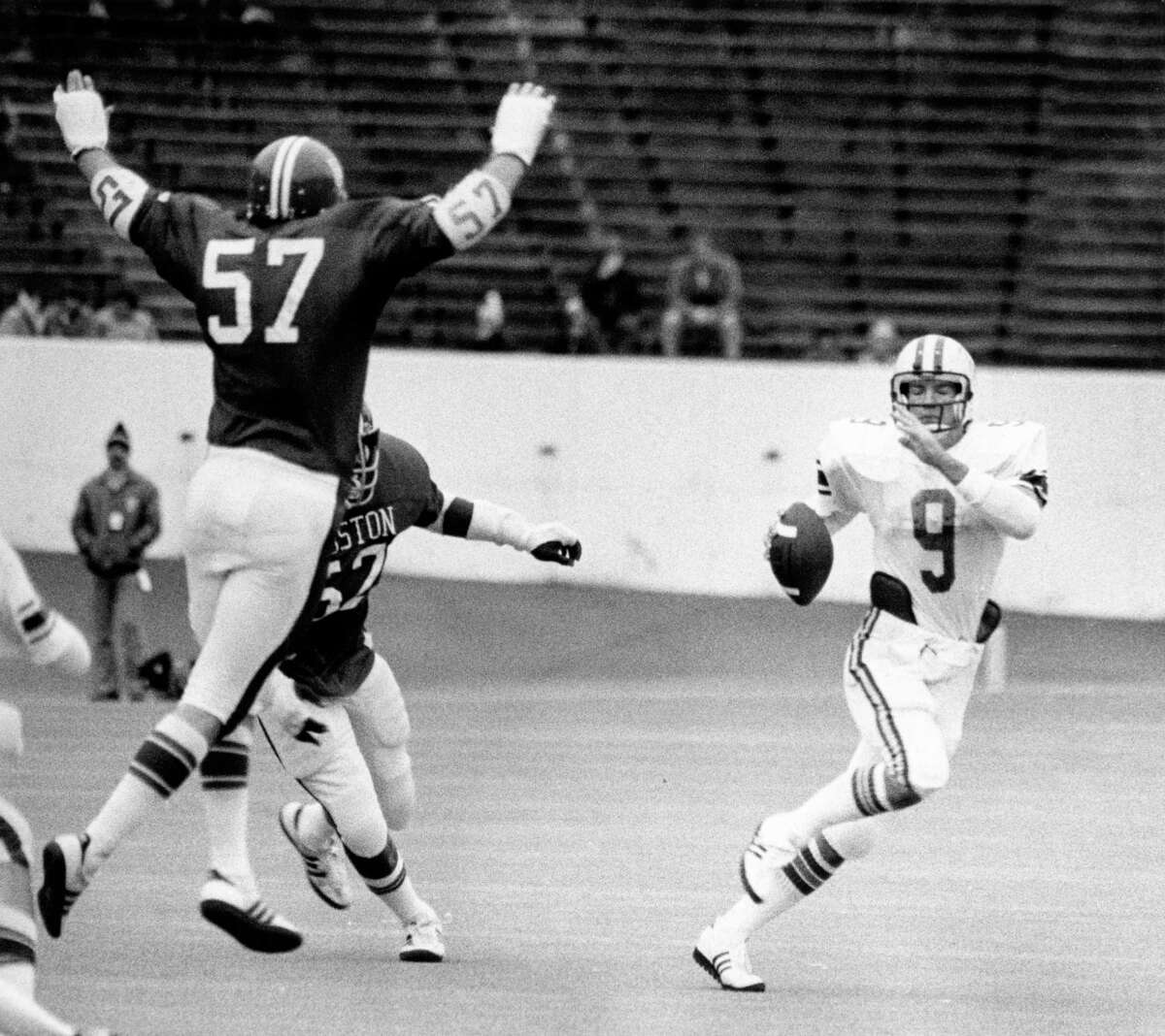 11/27/1976 - Houston Cougars Paul Humphreys (57) and Ross Echols go after Rice Owls quarterback Tommy Kramer (9) in the third quarter at Rice Stadium. Houston beat Rice 42-20 for their first Southwest Conference crown and to become the host team for the upcoming Cotton Bowl.