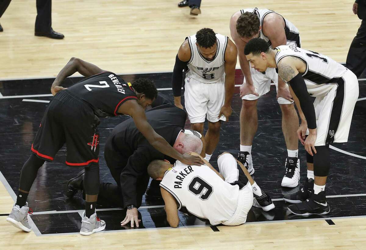 Houston Rockets’ Patrick Beverley (2) checks on the Spurs’ Tony Parker (9) along with Parker’s teammates (from left) Patty Mills, Pau Gasol and Danny Green and Spurs’ athletic trainer Will Sevening during the second half of Game 2 at the AT&T Center on May 3, 2017, in San Antonio. The Spurs announced on Thursday that Parker has a ruptured quadriceps tendon in his left leg.