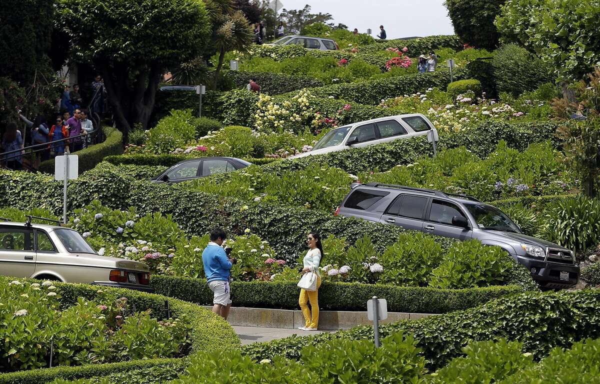 Motorists make their way down Lombard Street on Tuesday, May 20, 2014, in San Francisco. San Francisco's crooked street could soon be closed to tourists in the summertime. A transportation commission is scheduled to consider an experimental shutdown of the famously curvaceous block of Lombard Street plus an adjoining block where cars line up and wait.(AP Photo/Marcio Jose Sanchez)