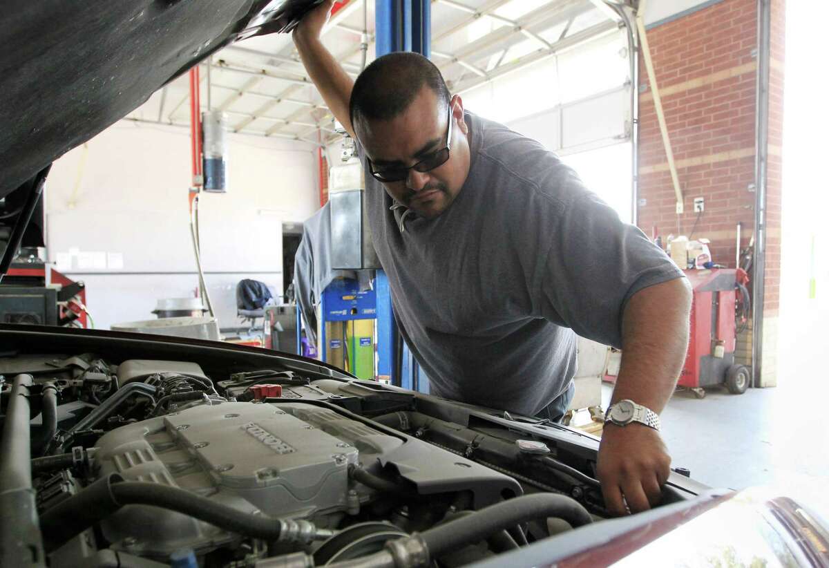 Johnny Pulido, a state vehicle inspector, performs an inspection in Houston in 2016. A bill that would end those inspections passed in the Senate on Thursday and now heads for the House.