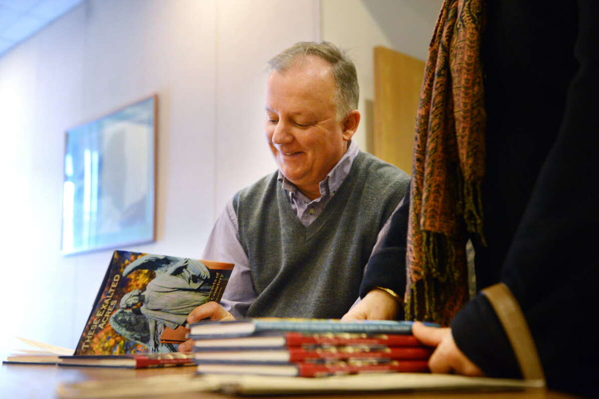 Paul Grondahl signs copies of "These Exalted Acres" and "The Story of Albany" on Dec. 10, 2014, during a book signing at the Times Union in Colonie. (Will Waldron / Times Union)