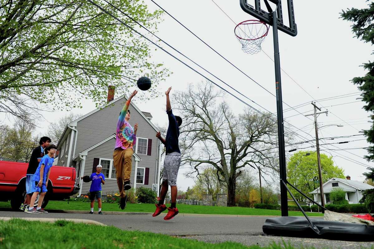 Friends play basketball together on Roseville Terrace in Fairfield on April 26.