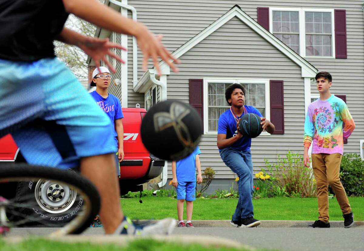 Friends play basketball together on Roseville Terrace in Fairfield, Conn. on Wednesday Apr. 26, 2017.