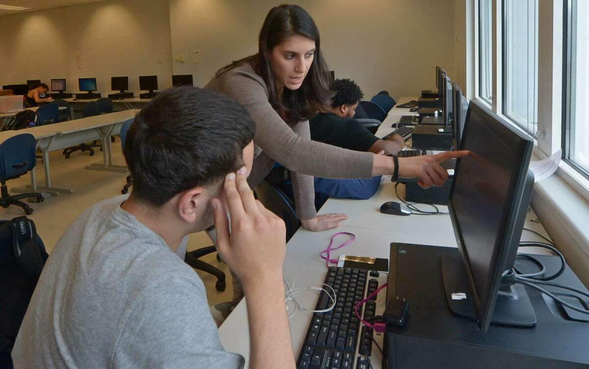 Brien McMahon High School math teacher Rosa Ayala helps students work on the APEX program, an online credit recovery program, Wednesday, May 3, at the school in Norwalk. Students attend the after school course to make up credit requirements they need to graduate.