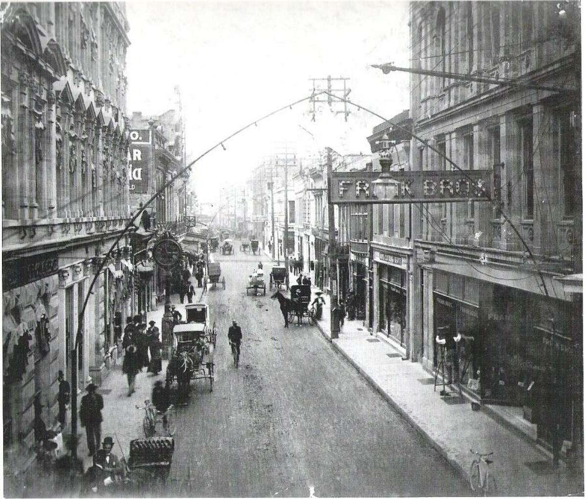 Buggies are parked and moving along Commerce Street in downtown San Antonio in 1900.