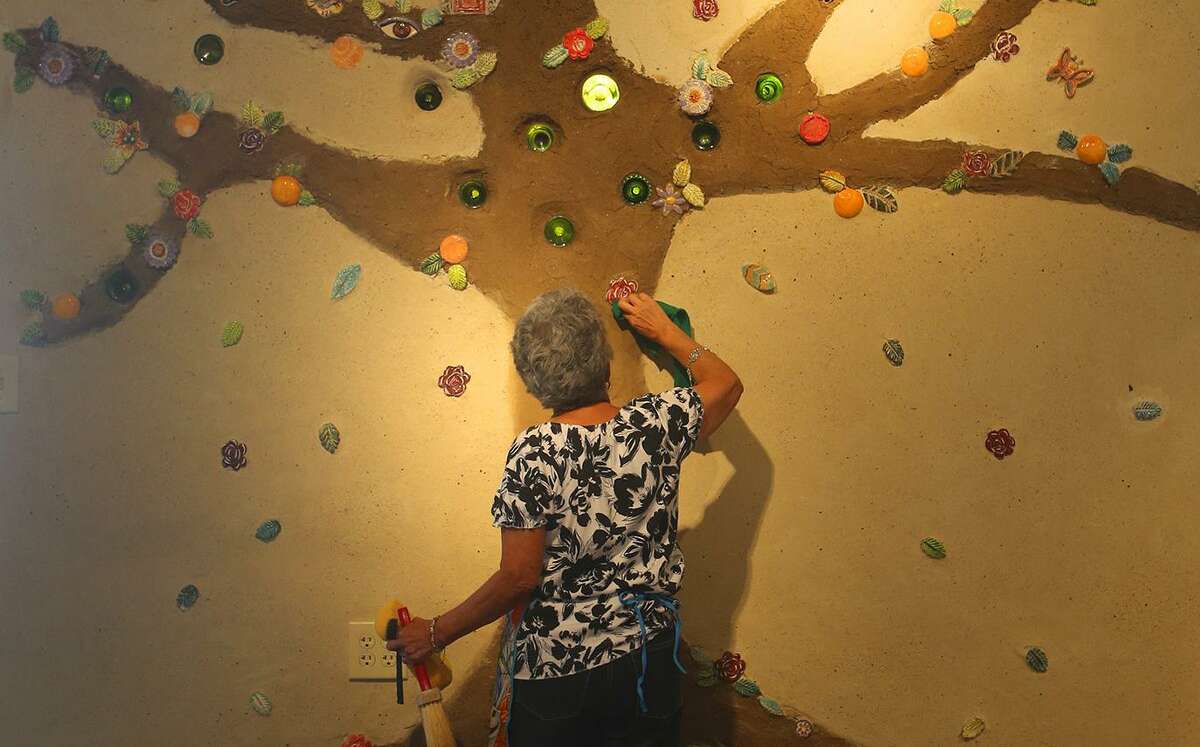 Olga Martinez, a member of MujerArtes, cleans new art work, part of a tree of life at MujerArtes’ new building on South Colorado Street. The new building will house the clay arts cooperative studio.