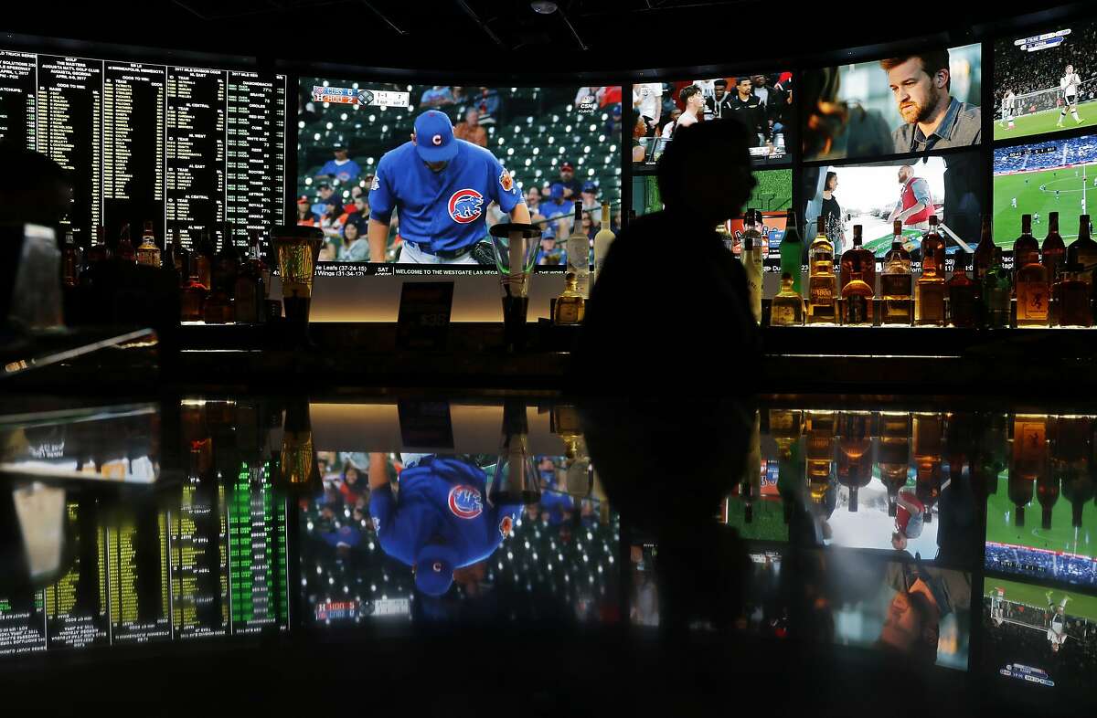 A screen showing a Chicago Cubs spring training baseball game is reflected with other screens on a countertop at the Westgate Superbook sports book, Friday, March 31, 2017, in Las Vegas. Oddsmakers in Las Vegas predict the Chicago Cubs will successfully defend their World Series title in 2017. The city's sports books like the team to win it all, with the biggest ones making them a 7-2 favorite to win it all again.(AP Photo/John Locher)
