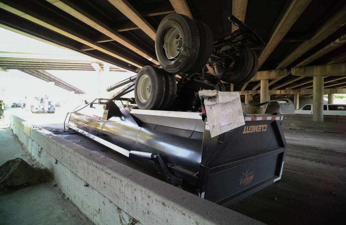 Authorities said the load of a dump truck was raised when the vehicle attempted to travel under a bridge in north Houston Friday.