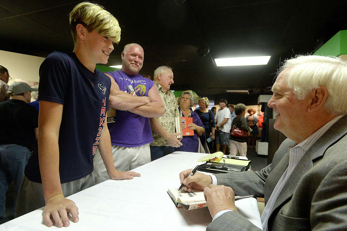 Wade Phillips talks with Lincoln Breaux, 11, who plays football in Bridge City as his father Benny Epperson looks on as he signs copies of his newly released book "Son of Bum : Lessons My Dad Taught Me about Football and Life" during an afternoon stop at theMuseum of the Gulf Coast in Port Arthur Friday. Phillips did a second signing event at Barnes & Noble in Beaumont that night. A long line of football fans, including several locals who grew up with or were coached by his father, snaked through the sports exhibit room and out into the hallway for the event. Photo taken Friday, May 5, 2017 Kim Brent/The Enterprise