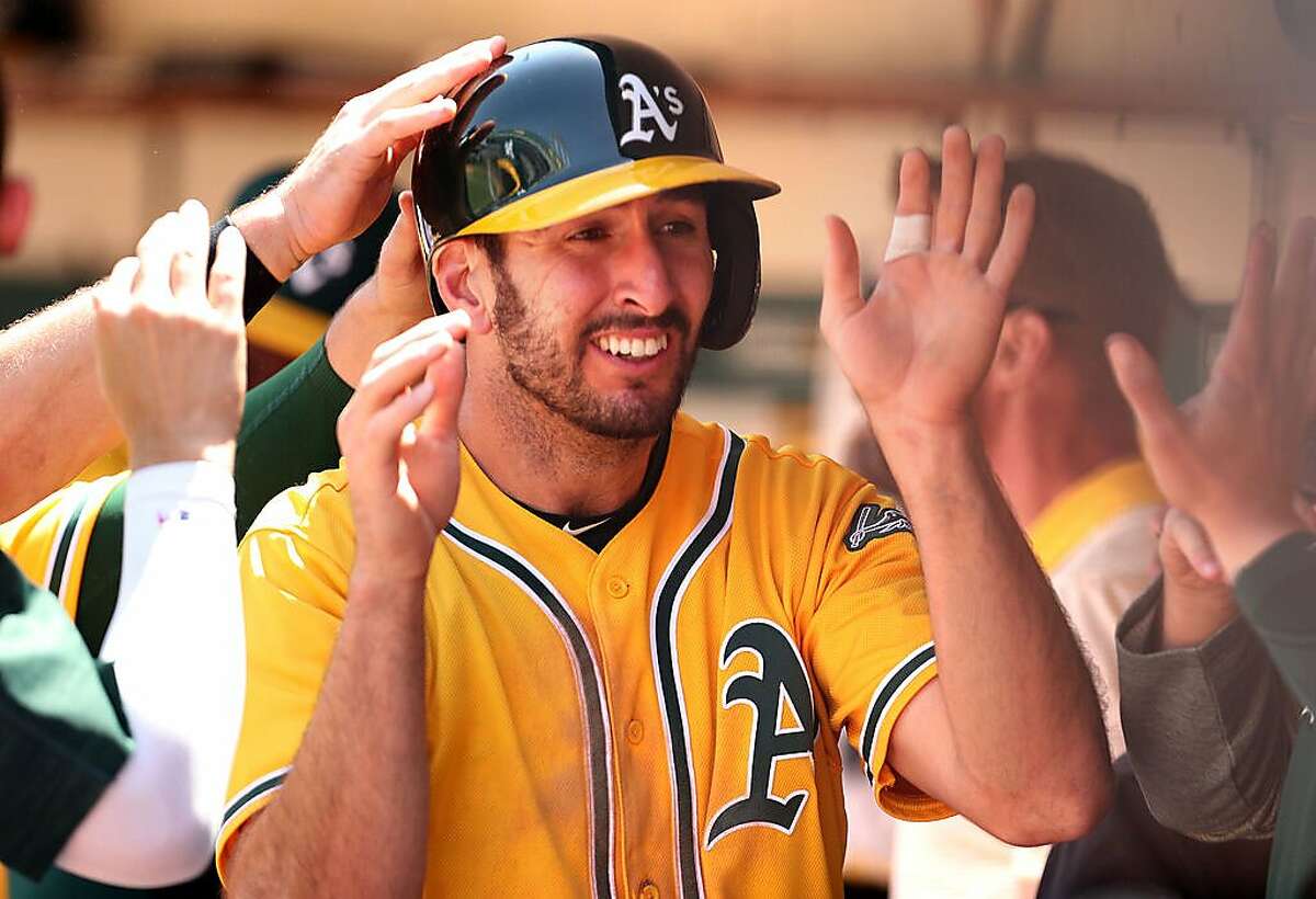 Oakland Athletics' Adam Rosales is welcomed back to the dugout after scoring on Rajai Davis' double in 3rd inning against Detroit Tigers during MLB game at Oakland Coliseum in Oakland, Calif., on Sunday, May 7, 2017.