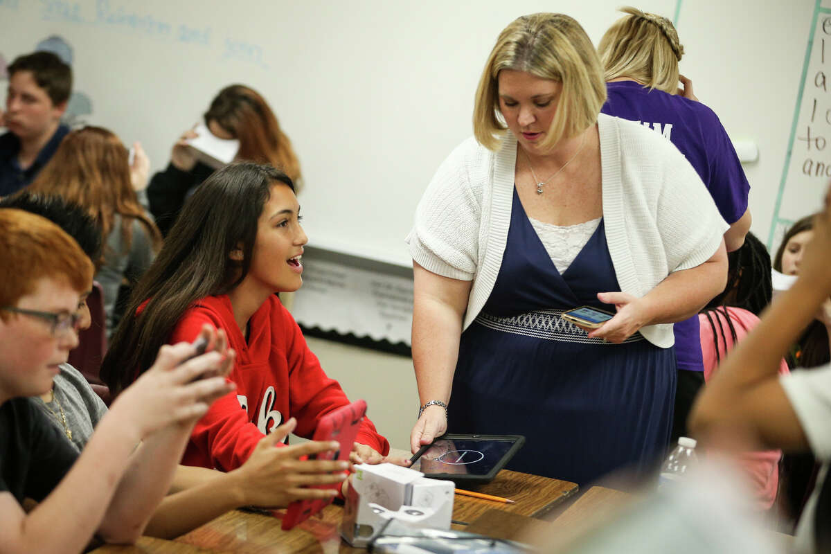 Willis ISD iCoach Ashley Soose helps set up a virtual reality viewfinder for 6th grader Jacquelyn Chomprasob during class on Friday, April 28, 2017, at Lynn Lucas Middle School.