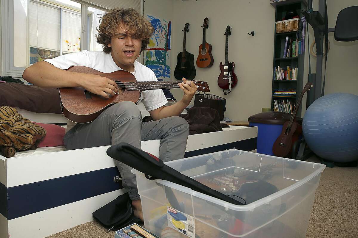 Sage Spencer, 17, plays ukulele in his room while he packs his belongings to pursue teaching and acting in Los Angeles on Friday, May 5, 2017, in San Francisco, Calif. Starting college at age 13, he graduated to be a substitute teacher. After applying and doing all the requirements, Sage experienced age discrimination.