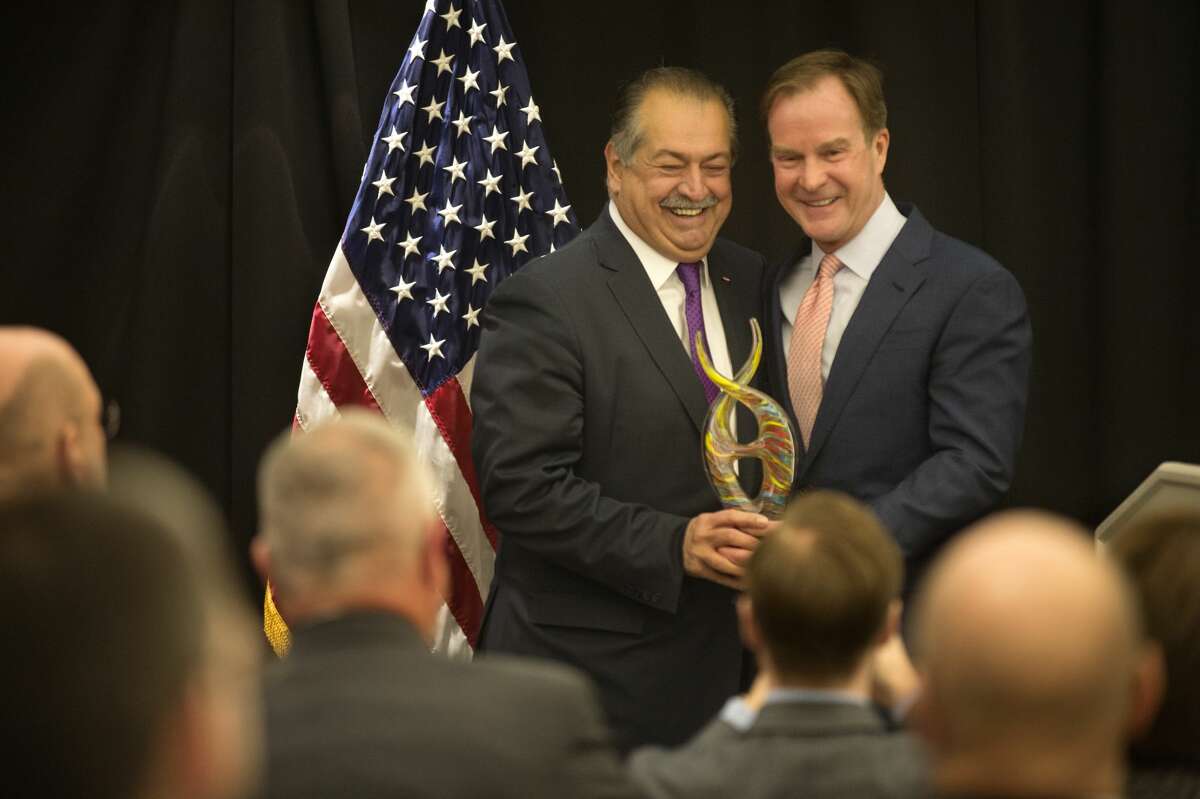 Chairman and CEO of The Dow Chemical Co. Andrew Liveris, left, accepts the Margaret A. Riecker Meritorious Service Award from Michigan Attorney General Bill Schuette during the Dave Camp Spring breakfast at the H Hotel Monday morning. "Andrew, you've made Midland a bigger and better community," Schuette said.