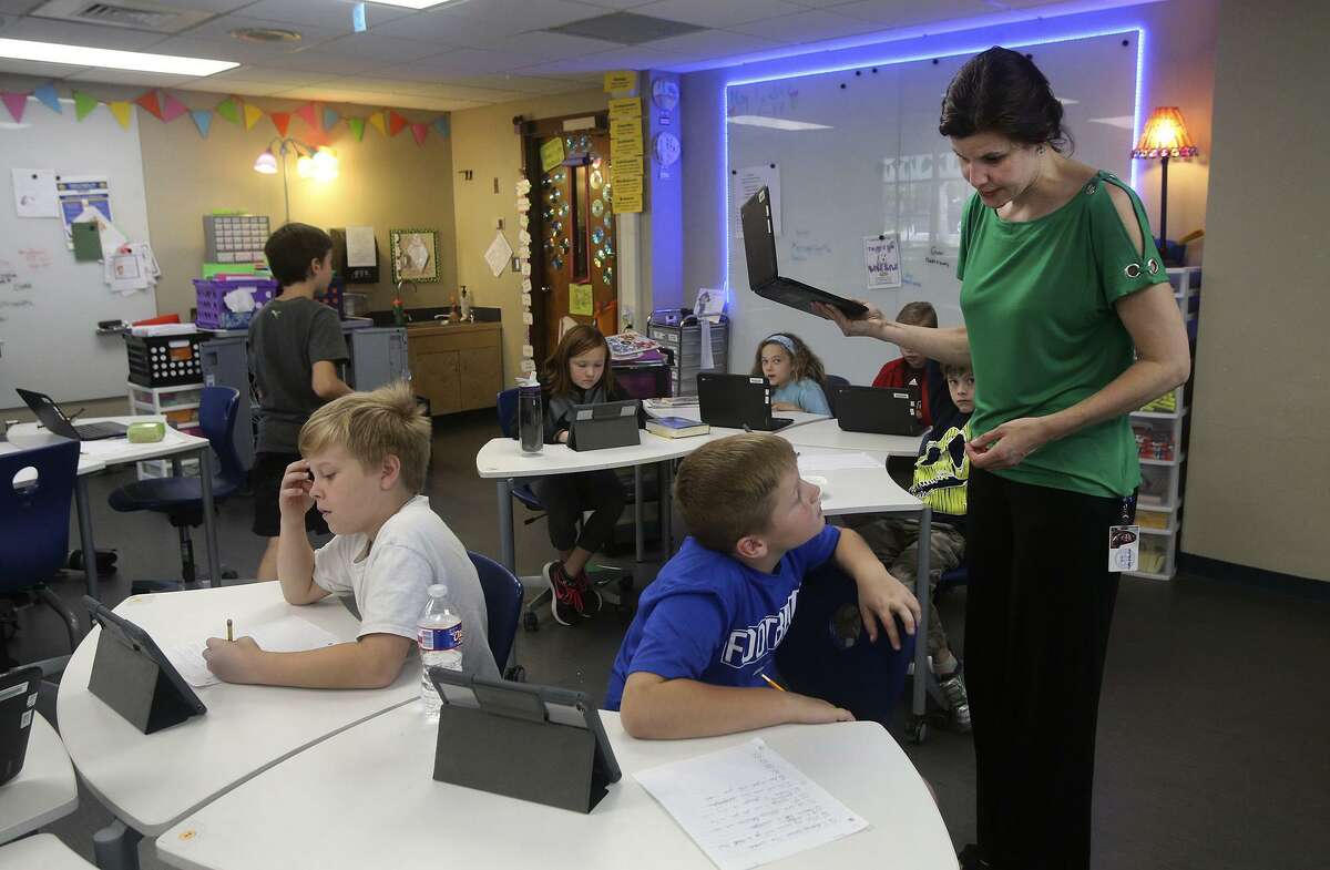 Students work on lessons with electronic devices Heather Smith's (right, standing) in fourth grade reading, writing and social studies class. The subjects are taught in what is called an "engaged" manner that lets kids learn at their own pace with a Google Classroom platform. Wheels are on furniture, lighting is controlled, and tables convert to whiteboards. Wobbly stools are used as well as bean bag chairs. Smith's engaged classroom is one of only 17 in the Alamo Heights District.