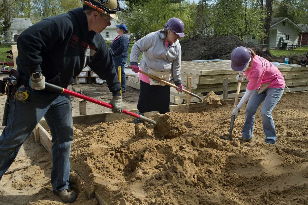From left: Valley Electric employee Becky Manson, Senior Services employees Emily Eastman and Michelle Lather level sand on the soon to be garage floor during Habitat for Humanity's 10th annual National Women Build Week Tuesday morning.