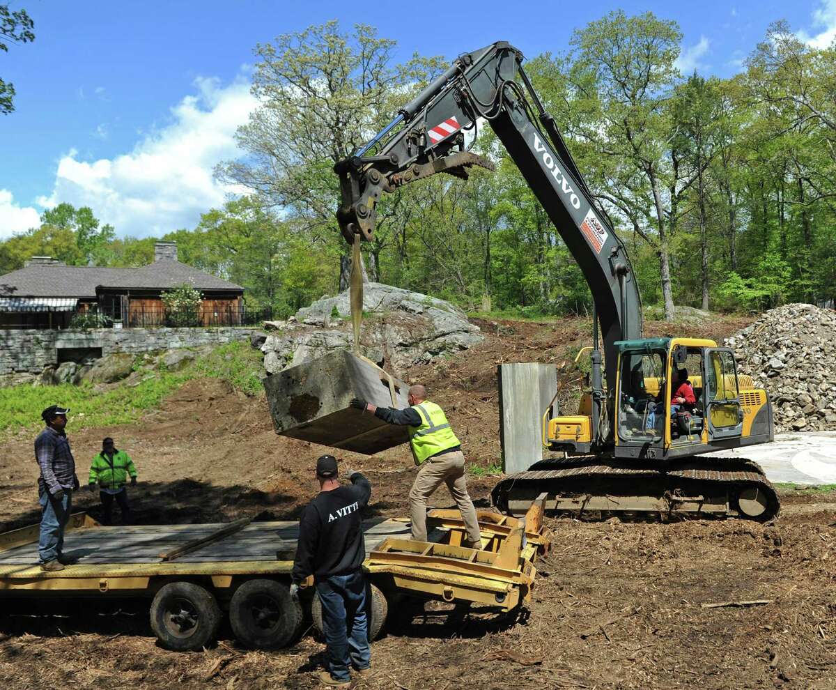 A construction crew works on disassembling the marble backyard amphitheater in Cos Cob.