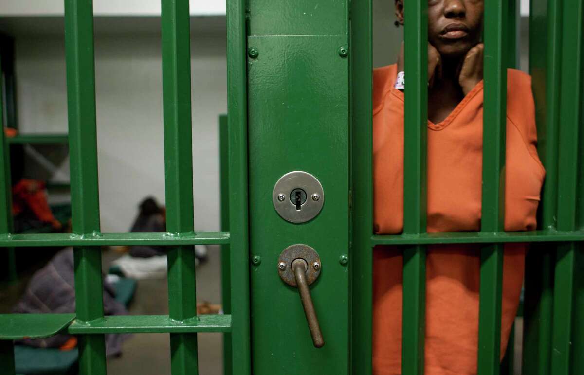An inmate peers out at activity outside her cell at the Harris County Jail in Houston. (Chronicle File Photo)
