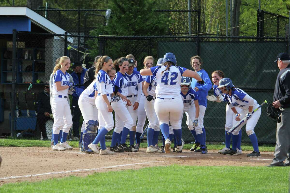 Darien’s Sophia Barbour (42) is greeted at home plate after her three-run homer in the sixth inning of Monday’s game against New Canaan at Darien High School.