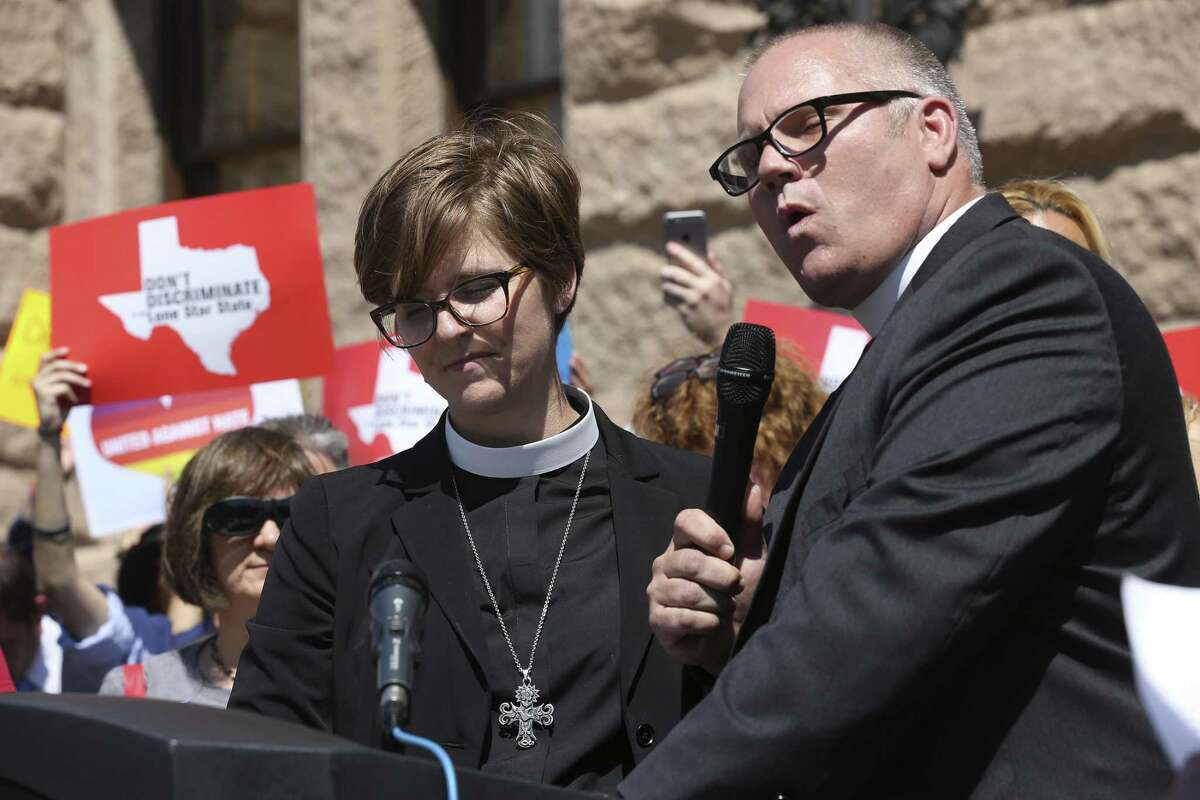 Rev. Taylor Fuerst and her husband, Rev. Brad Fuerst, pray during an invocation at an LGBTQ rally in front of the state Capitol building on March 20. Members of the LGBTQ community and other advocates have been protesting numerous bills they see as discriminatory, including a measure approved by the Texas House on Wednesday night that would allow child welfare service providers that work with the state to reject foster and adoptive parents if their religious beliefs differ from those of the organization's.