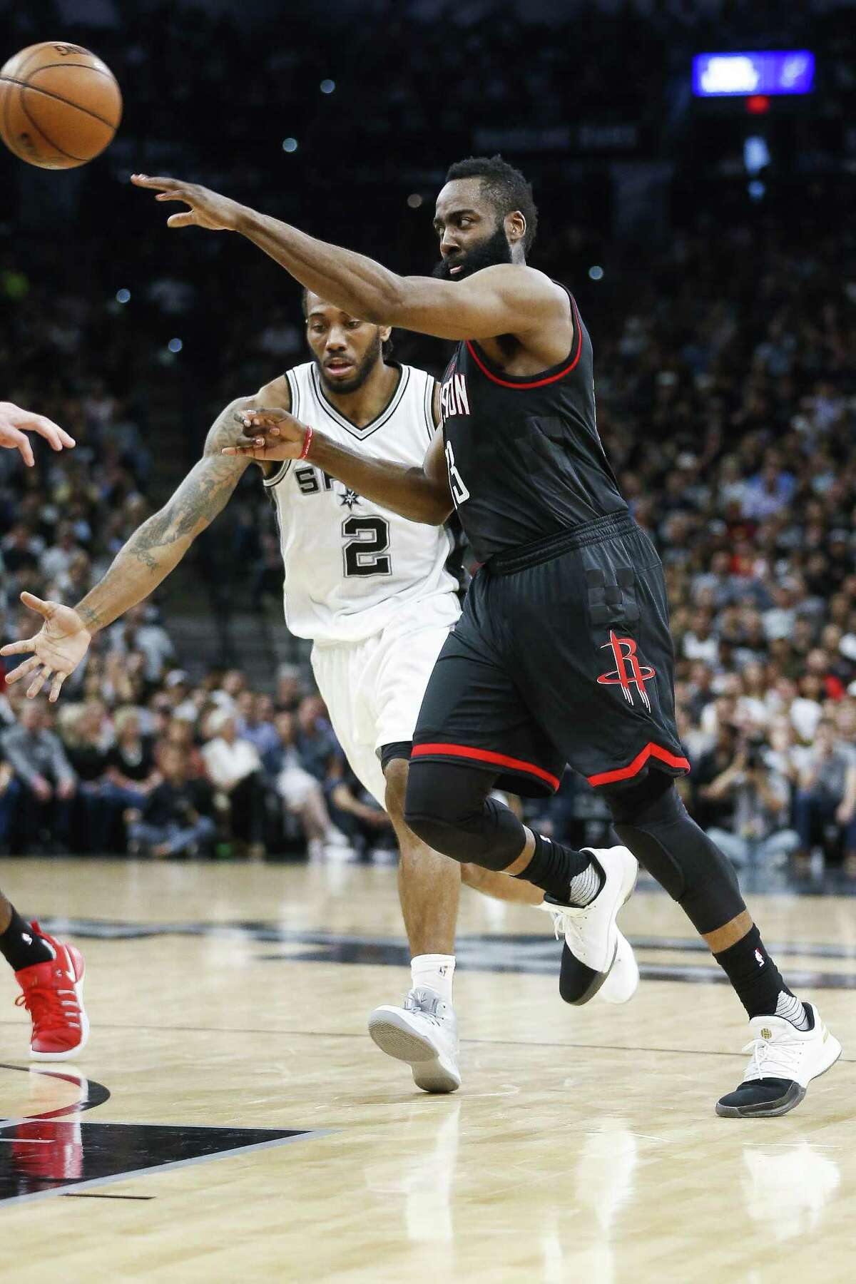Rockets guard James Harden makes a pass past Spurs forward Kawhi Leonard during the first half of Game 5 at the AT&T Center on May 9, 2017, in San Antonio.