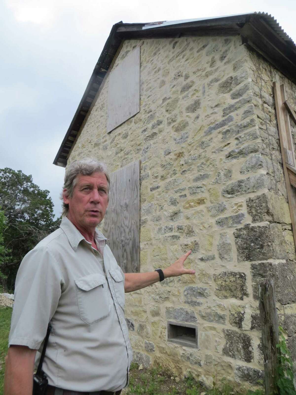Park Ranger John Koepke shows where masonry repairs were recently made to a crumbling wall on the Zizelmann House, located in Government Canyon State Natural Area.