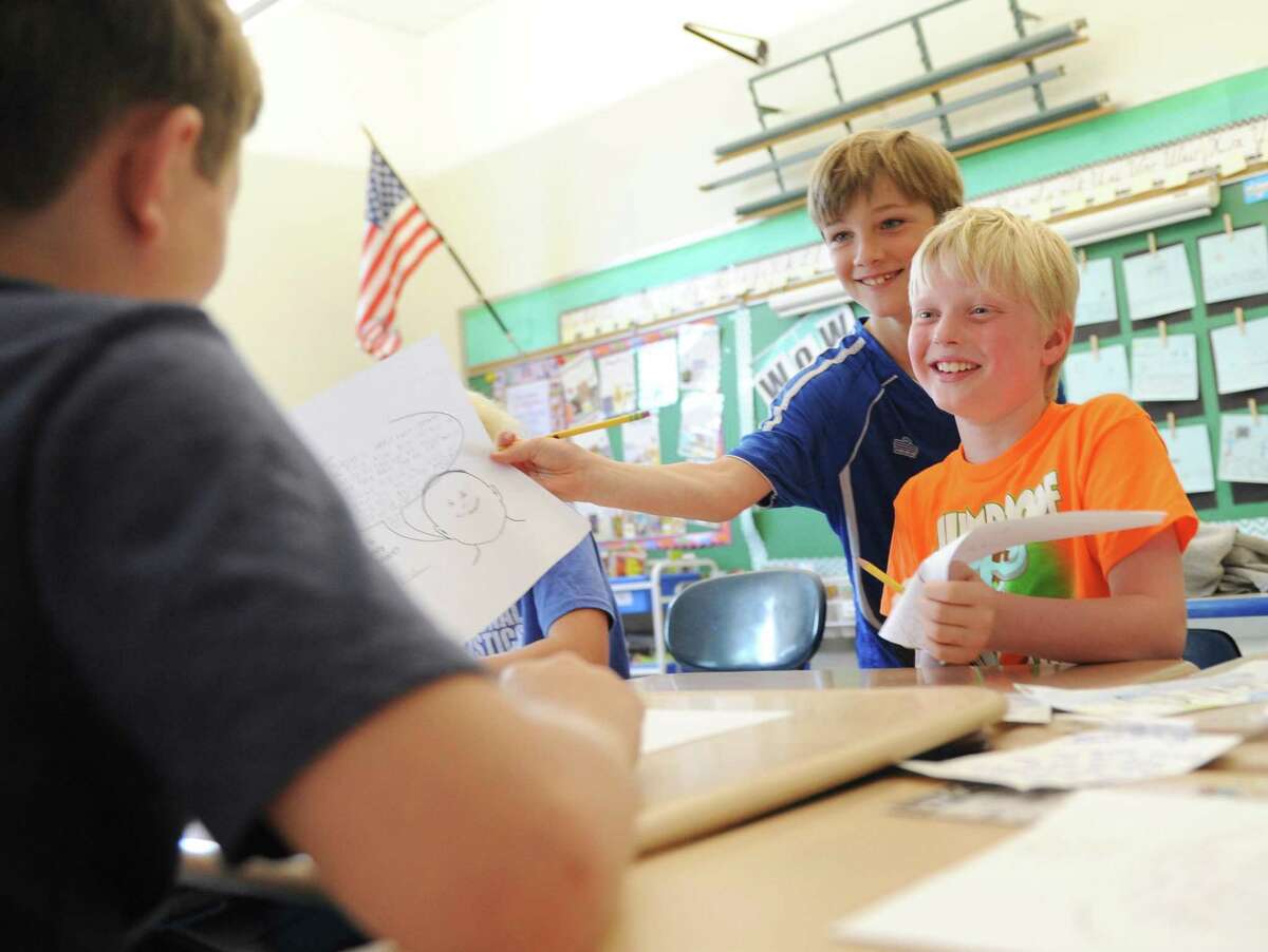 Third-graders Brendan King, left, and Brody Craven show another student their reasons why it is important to be honest during a class lesson on honesty at Old Greenwich School in Old Greenwich, Conn. Wednesday, May 10, 2017. "Be Honest, Character Matters" is a common initiative across grade levels to teach students the importance of being honest and taking responsibilities for one's actions.