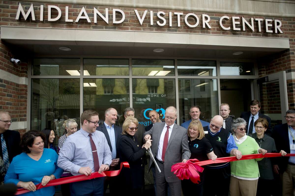 CEO of Go Great Lakes Bay Annette Rummel, left, and Chairman of the Board Tim Shelton cut the ribbon during the open house for the new Midland Visitors Center Wednesday afternoon. The new visitors center shares the main floor of the H Residence with the Northwood Gallery and soon to open Italian restaurant Gratzi.