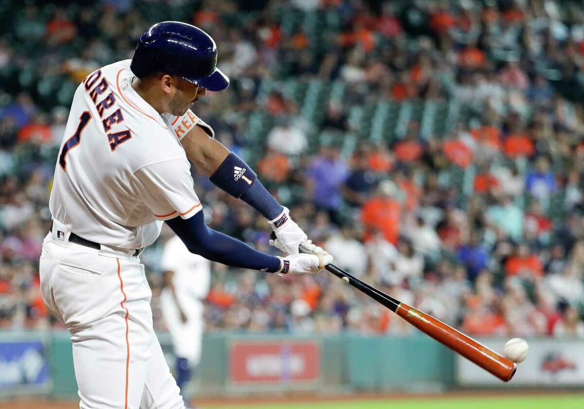 Houston Astros' Carlos Correa (1) hits a two-run double as Atlanta Braves catcher Kurt Suzuki reaches for the pitch during the fifth inning of a baseball game Wednesday, May 10, 2017, in Houston. (AP Photo/David J. Phillip)