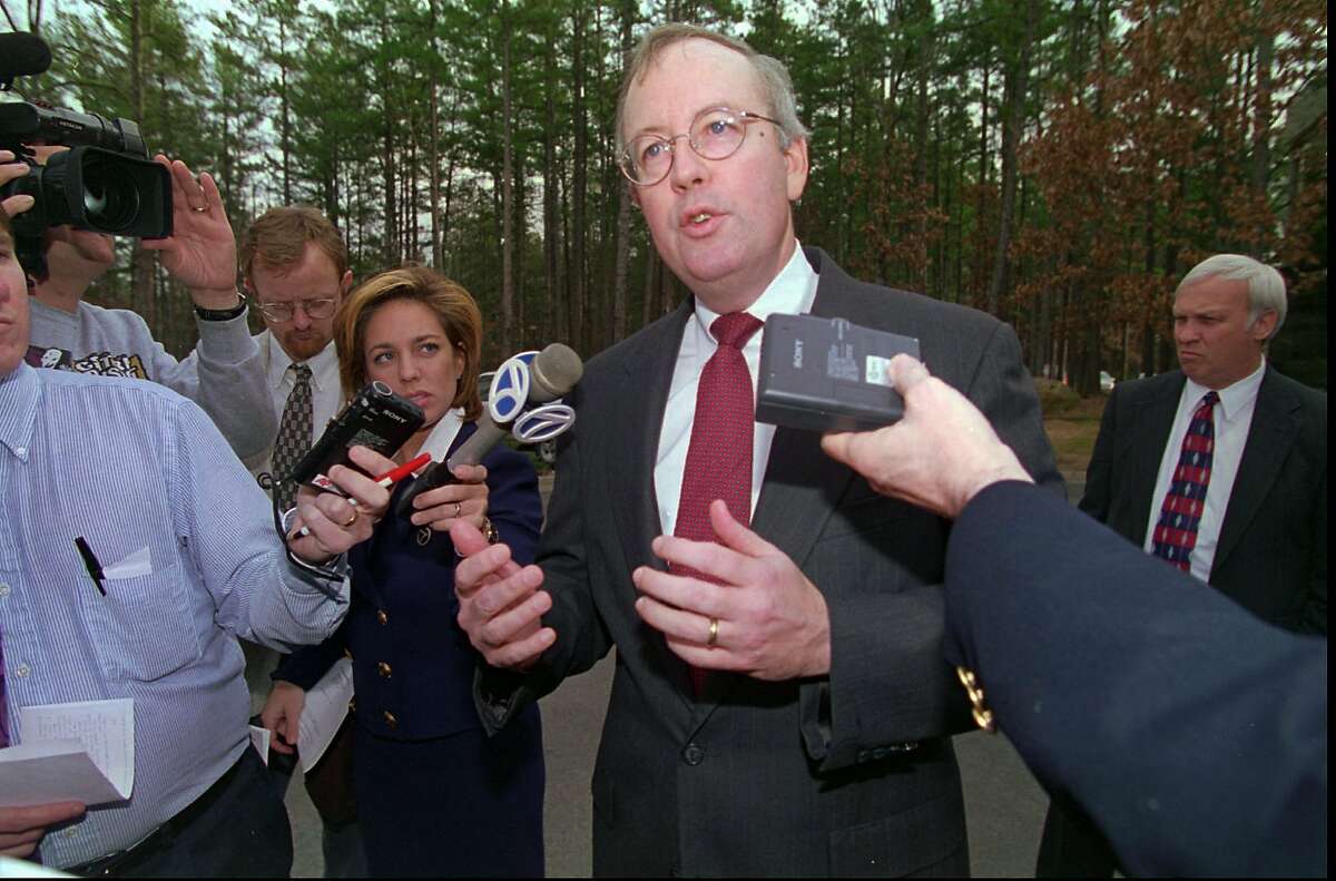 Whitewater independent counsel Kenneth Starr is surrounded by reporters as he walks in front of his Little Rock, Ark., office building Tuesday, Feb. 18, 1997. Starr said the investigation of President Clinton's Arkansas business dealings will continue with a new independent counsel after he leaves his job this summer to take a position at Pepperdine University. (AP Photo/Danny Johnston)