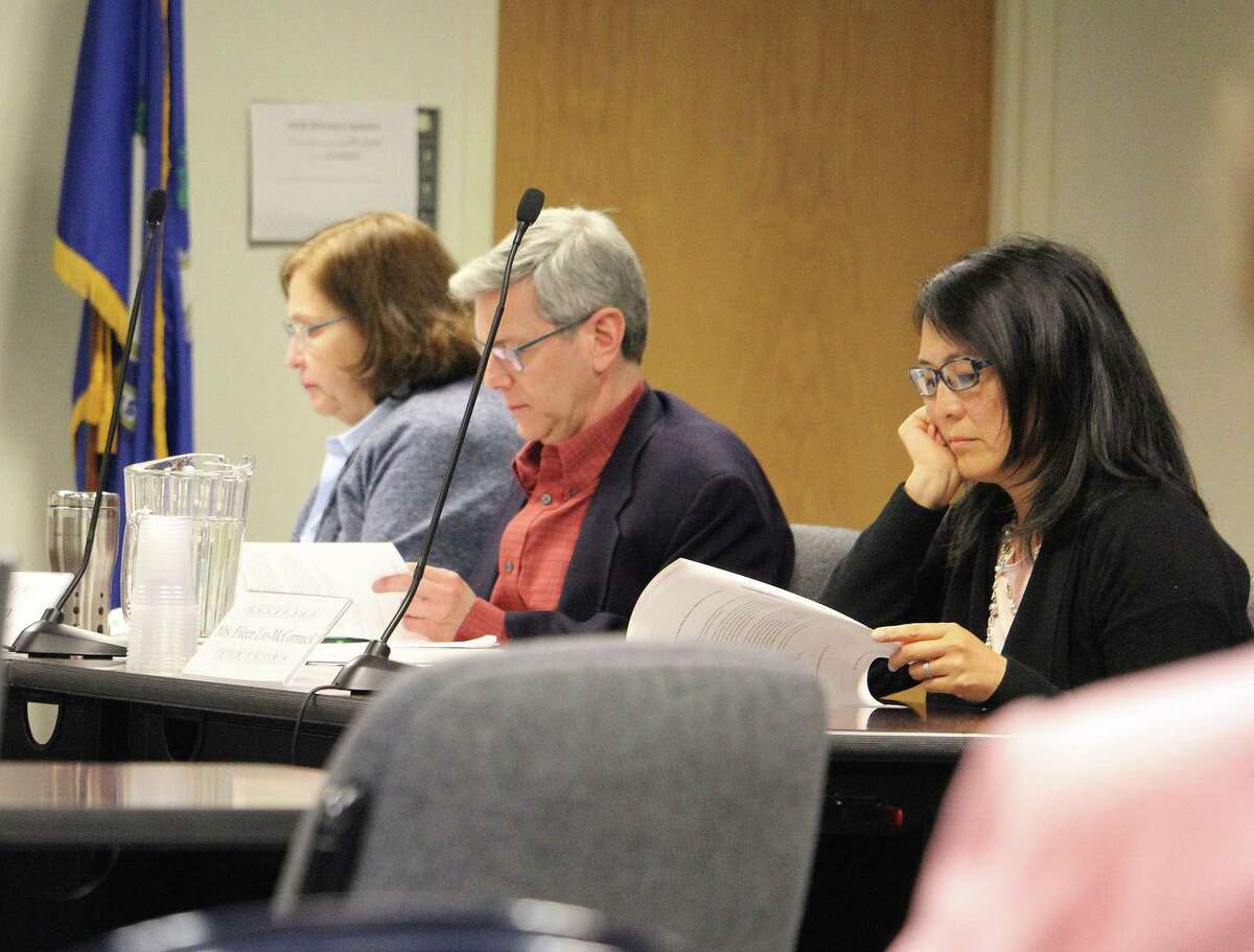 Board of Education members Donna Karnal, left, Marc Patten and Eileen Liu-McCormack listen during a discussion on solar carports at Fairfield, Conn. high schools during a May 9, 2017 school board meeting.