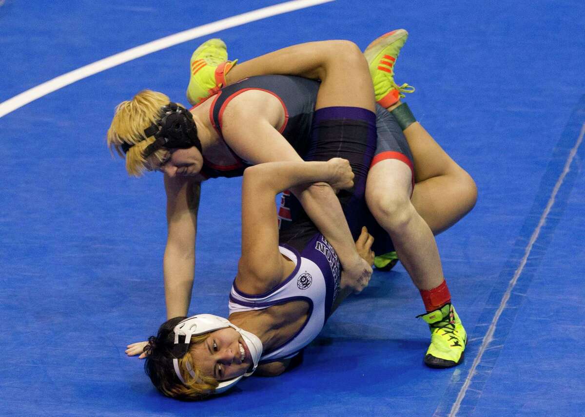FILE - In this Feb. 25, 2017, file photo, Euless Trinity's Mack Beggs, top, drives Morton Ranch's Chelsea Sanchez against the mat during the girls Class 6A 110-pound championship final at the UIL state wrestling championships in Cypress, Texas. When Texas transgender wrestler Mack Beggs won a girlsÂ?’ state championship, his victory drew jeers and complaints that his steroid therapy treatment had given him an unfair advantage against girls who risked injury just by getting on the mat with him, Now state lawmakers are pushing a bill that could deny Beggs, a Dallas area-junior, a chance to defend his title. (Jason Fochtman/Houston Chronicle via AP, File)